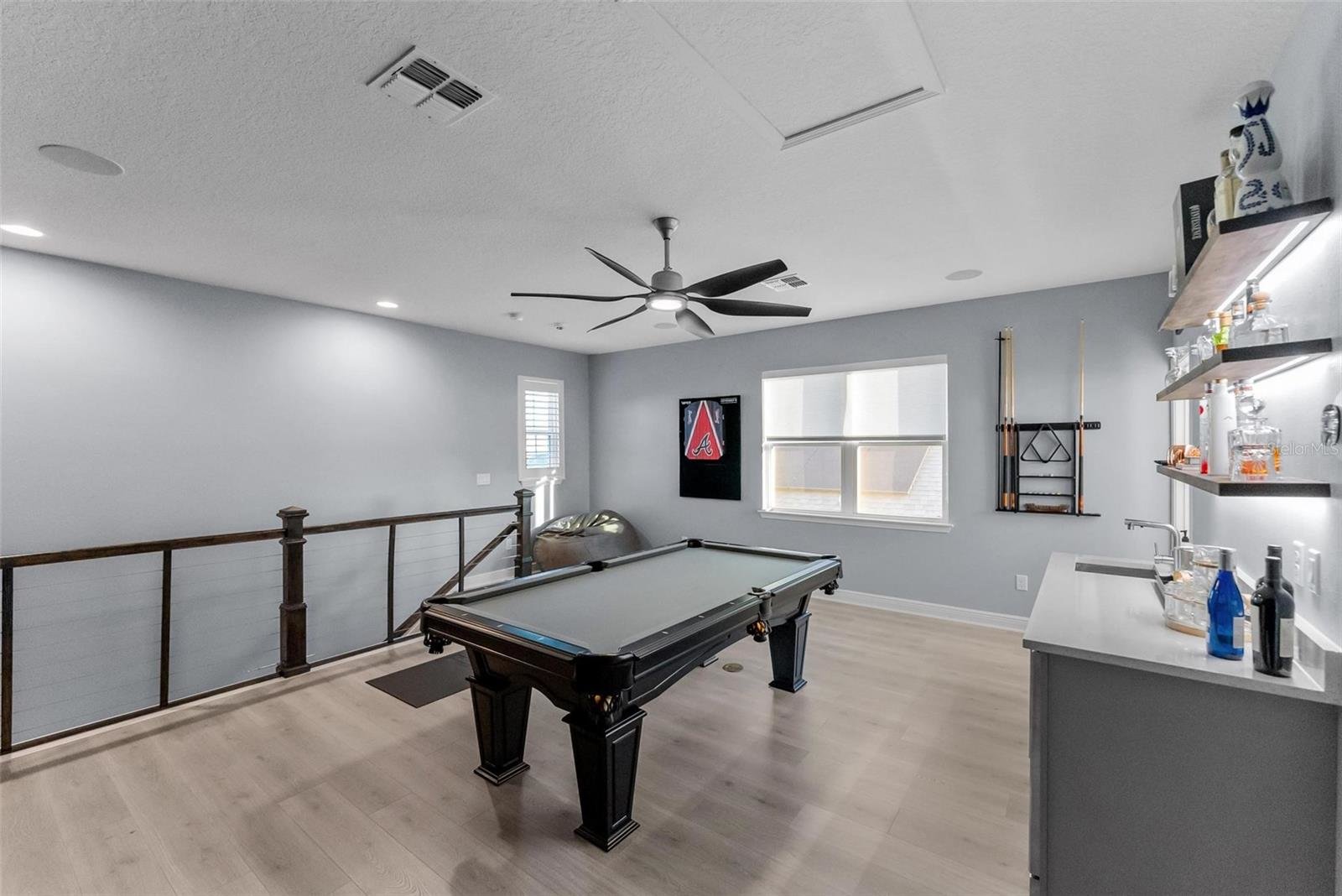upstairs loft with pool table and wood flooring